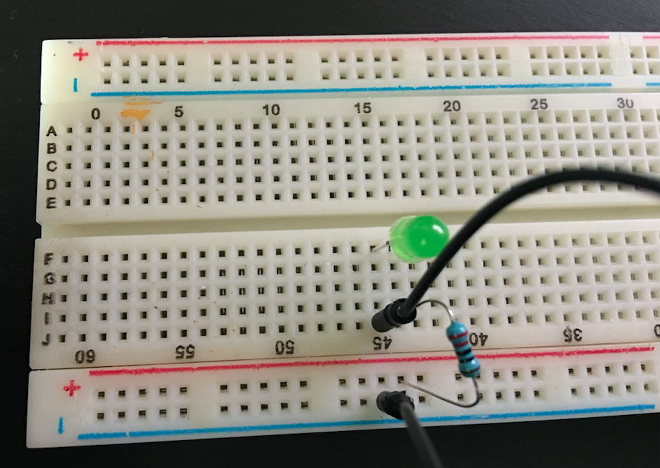 Breadboard with 220 ohm resistor,green LED and jump wire ground connection